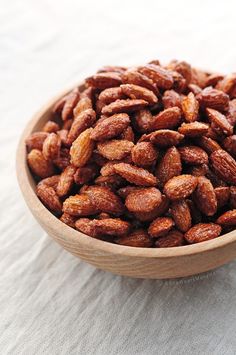 a wooden bowl filled with nuts on top of a table