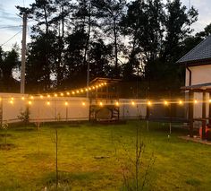 the backyard is lit up with string lights