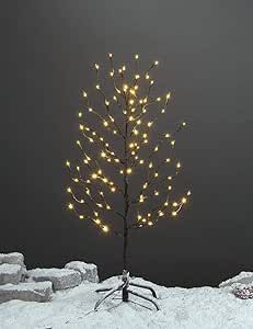 a small tree is lit up in the snow