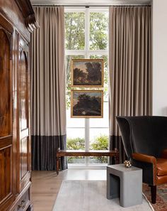 a living room filled with furniture next to a window covered in curtains and drapes