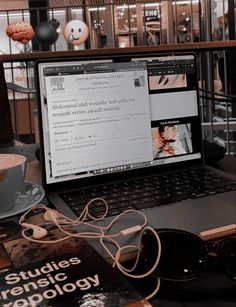 an open laptop computer sitting on top of a table next to a cup of coffee