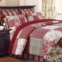 a bed with red and white quilts on it