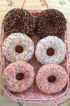 four donuts in a basket with sprinkles on the outside and inside