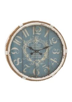 a blue and white wall clock with numbers on it's face, hanging from a rope