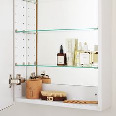 a bathroom shelf filled with personal care items and a brush on top of the shelf