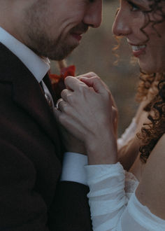 a bride and groom smile at each other