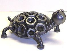 a small metal turtle sitting on top of a white table