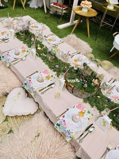 a table set up with plates, cups and utensils for an outdoor tea party