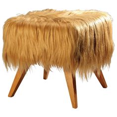 an animal fur foot stool with wooden legs