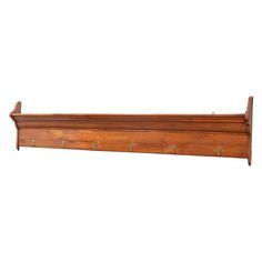 a wooden shelf with three hooks on the top and two small handles at the bottom