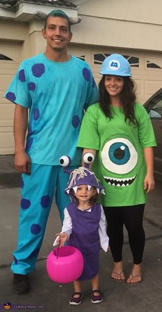 two adults and a child in costumes standing next to each other