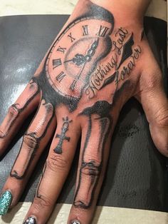 a person's hand with tattoos on it and a clock tattooed on the palm