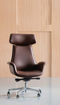 a brown office chair sitting on top of a white floor next to a wooden wall