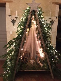 a nativity scene with lights and greenery