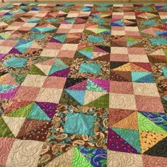 a bed with a colorful quilt on top of it