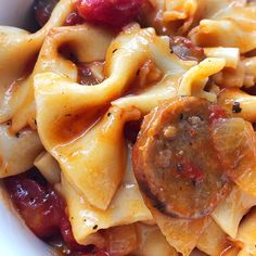 pasta with sausage and cranberry sauce in a white bowl