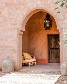 an archway leading to a patio with wicker furniture