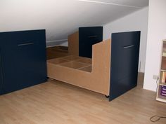 an empty room with some blue cabinets and bookshelves on the floor in front of it