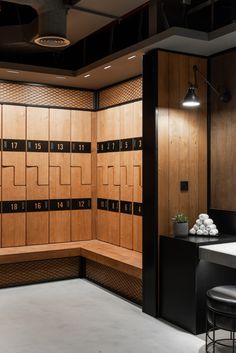 a room with several wooden lockers and stools in front of the counter top