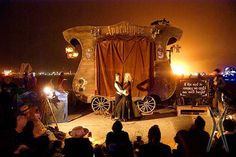 a woman standing on top of a stage in front of a group of people at night