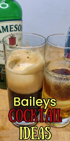 two glasses filled with drinks sitting on top of a wooden table