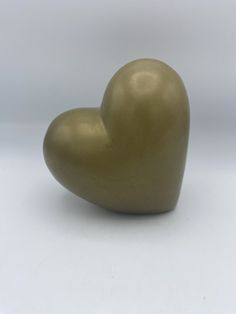 a gold heart shaped object on a white background