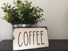 a potted plant sitting on top of a table next to a sign that says coffee