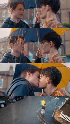 two young men kissing under an umbrella in the rain while another man looks on from behind them