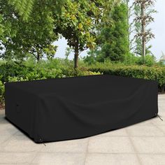 an outdoor table and chair cover in the middle of a patio with trees behind it