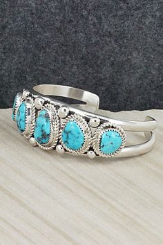 This stunning turquoise and sterling silver bracelet was made by Navajo silversmith Leslie Nez. The inside is signed Leslie Nez and stamped sterling.Size: 5 3/4" (will fit up to a 7" wrist)Gap: 1 1/4"Width: 1"Free shipping on all orders! We ship with USPS and always include tracking. All orders ship within a day of payment.Returns are accepted up to 30 days after you receive your order. Just send us a message. Our shop offers cash back or store credit. The item must be returned in new condition. Silversmithing Jewelry, Wrist Jewelry, Gem Stones, Sterling Silver Bracelet, Silver Turquoise, Ring Bracelet, Sterling Silver Bracelets