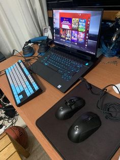 a laptop computer sitting on top of a wooden desk next to a mouse and keyboard