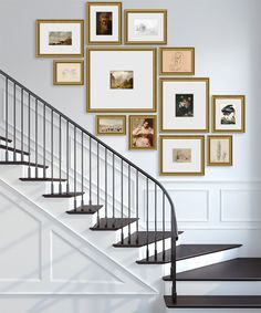 there is a staircase with many pictures on the wall next to it and some stairs