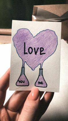 someone holding up a piece of paper with the words love and two flasks