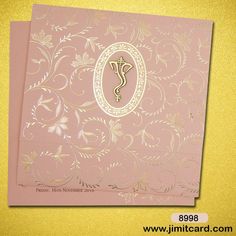 a pink and gold wedding card with an ornate design on the front, featuring a monogram