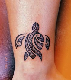 a turtle tattoo on the foot of a woman's leg, with an intricate design