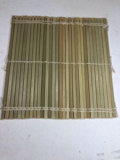 two pieces of bamboo sitting next to each other on a white surface with holes in it