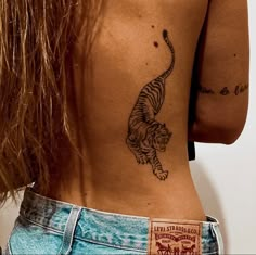 a woman with a tiger tattoo on her lower back and the upper half of her body