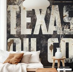 a bed sitting under a white light next to a wall with the words texas on it