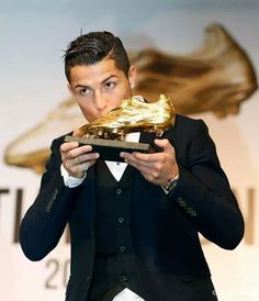 a man in a tuxedo eating a golden piece of food with his hands