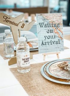 a table set up with water bottles, plates and napkins for an airplane themed birthday party