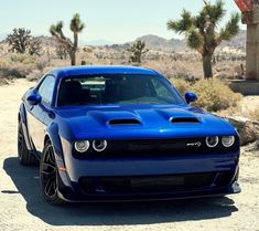 a blue dodge car parked in the desert