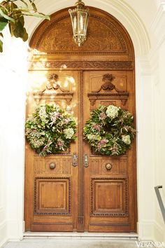 two large wooden doors with wreaths on the front and side panels, one is decorated with flowers