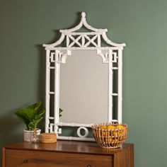 a white mirror sitting on top of a wooden dresser