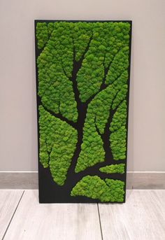 a painting with green moss growing on it's sides in a white floored room