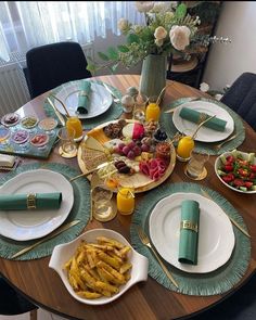 the table is set with plates, silverware, and green napkins on it