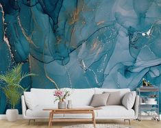 a living room with a white couch and blue marble wallpaper on the walls, along with a wooden coffee table