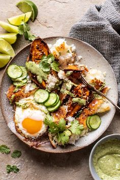 a plate full of food with eggs, cucumber and avocado on the side