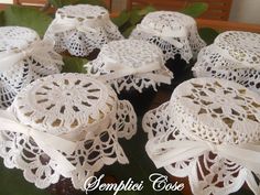 several white doily covered cakes sitting on top of a table