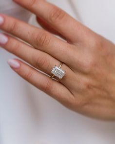 a woman's hand with a diamond ring on it