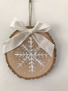 a snowflake ornament hanging on a wall next to a white ribbon